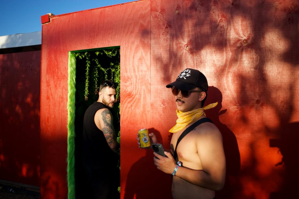 Two gay men meeting for fun encounter at a festival outdoors in one of the benefits of open relationships.

