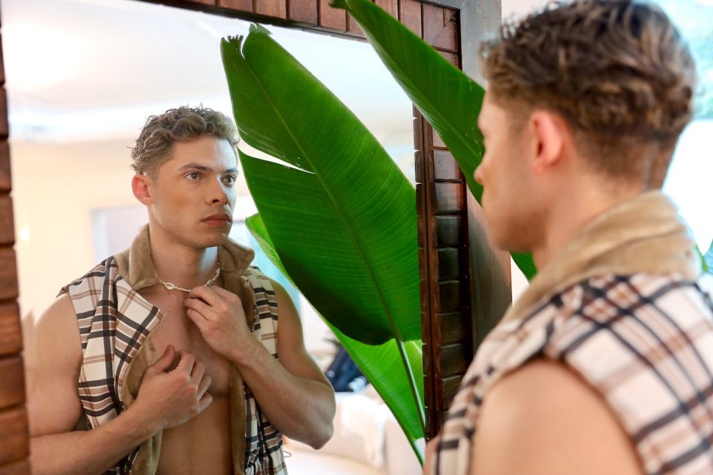 A man looking intensely at himself in a mirror as a metaphor for the perfectionism that can precede gay depression
